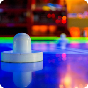 Air hockey paddle on a glowing air hockey table