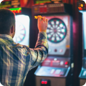 Player throwing a dart at an electronic darts arcade